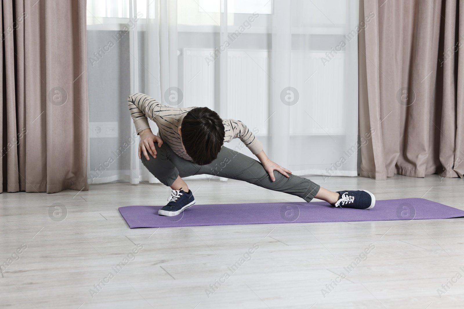 Photo of Little boy exercising at home. Morning routine