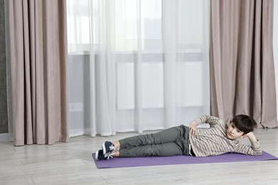 Photo of Little boy exercising at home, space for text. Morning routine