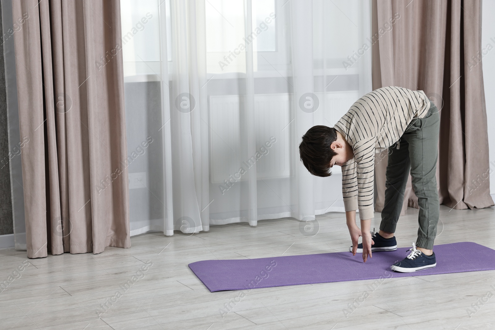 Photo of Little boy exercising at home, space for text. Morning routine