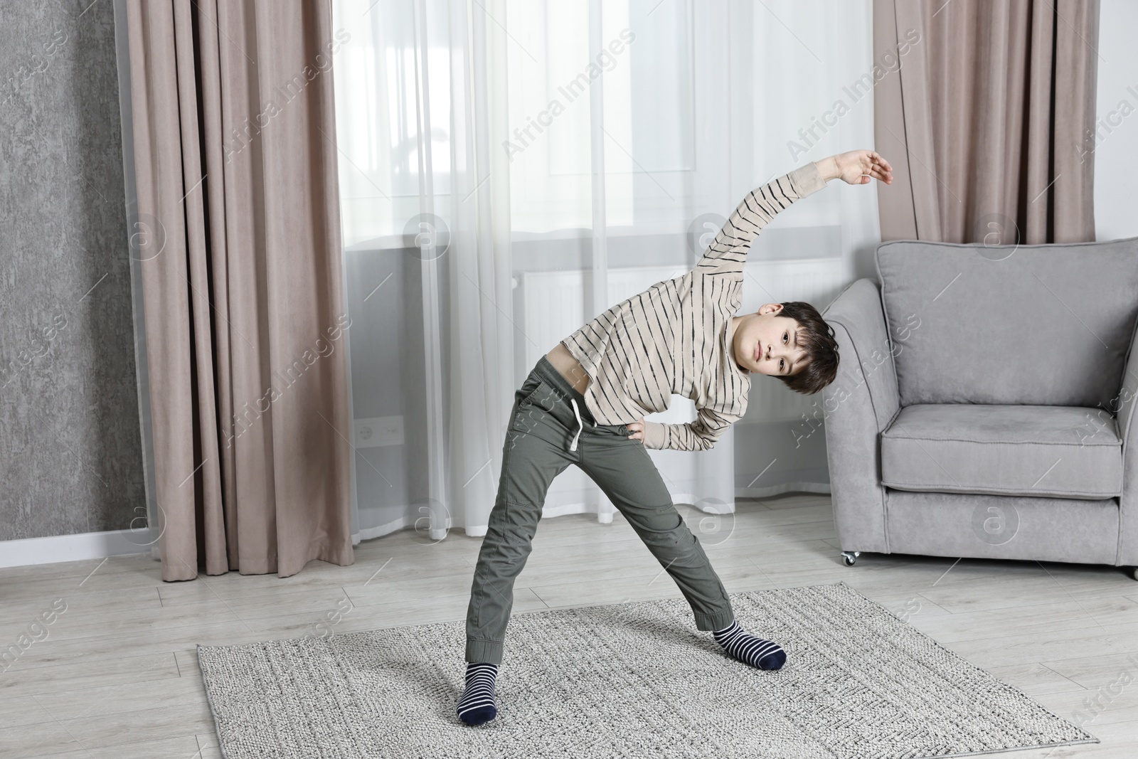 Photo of Little boy exercising at home. Morning routine