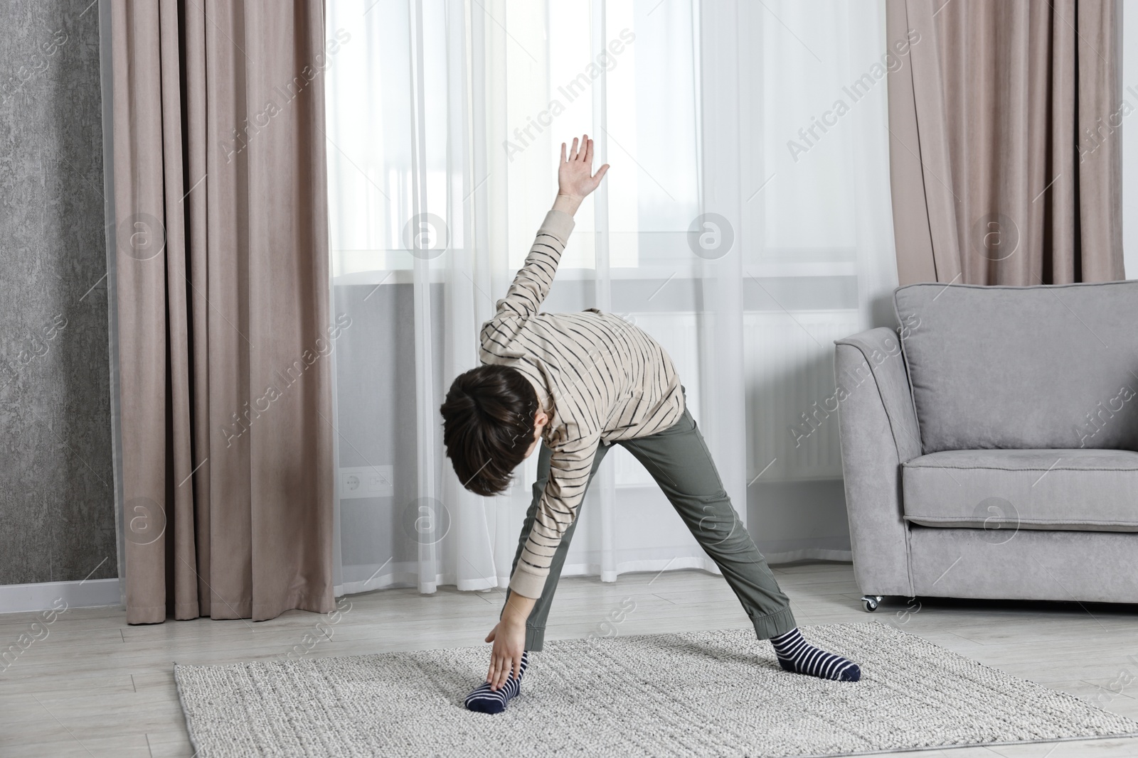 Photo of Little boy exercising at home. Morning routine