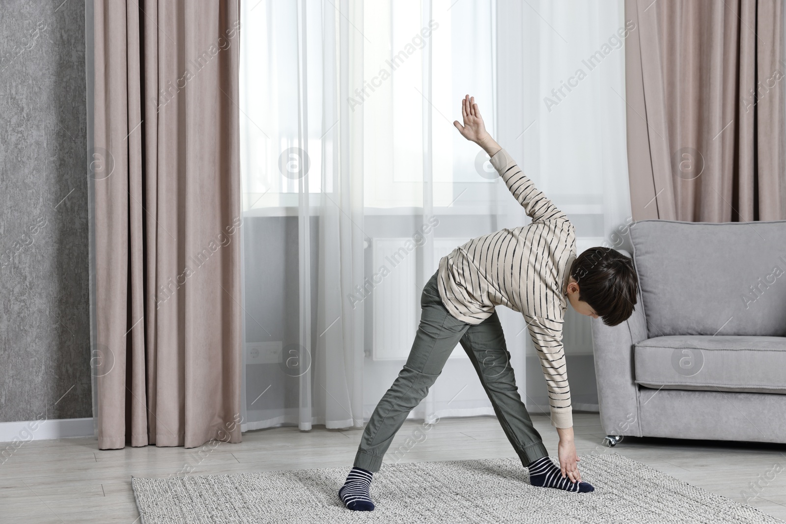 Photo of Little boy exercising at home. Morning routine