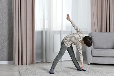 Photo of Little boy exercising at home. Morning routine