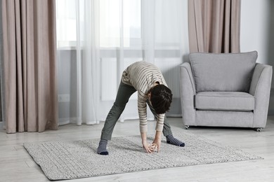 Photo of Little boy exercising at home. Morning routine