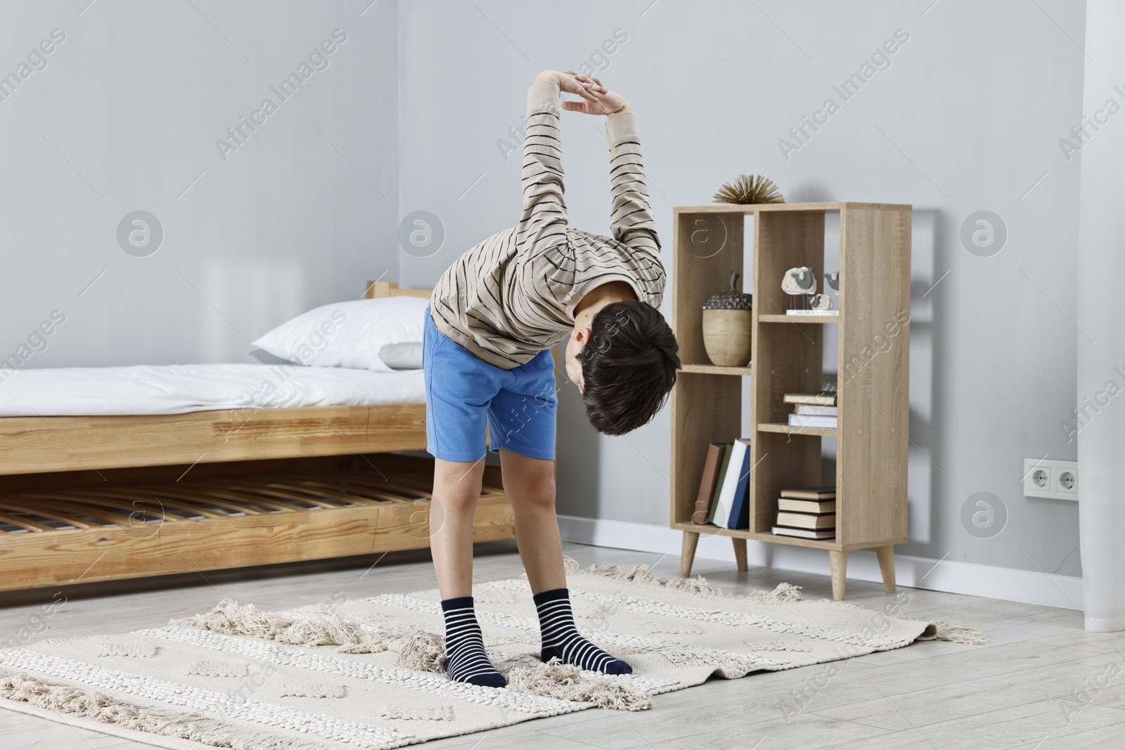 Photo of Little boy exercising at home. Morning routine