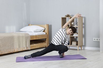 Photo of Little boy exercising at home. Morning routine