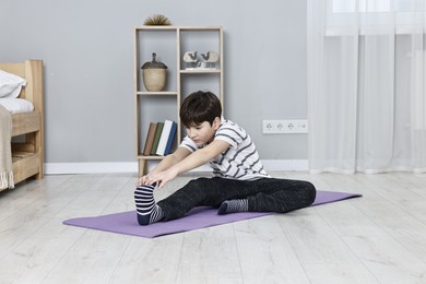 Photo of Little boy exercising at home. Morning routine