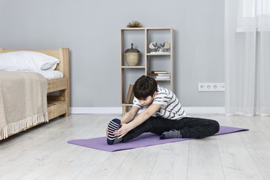 Photo of Little boy exercising at home. Morning routine