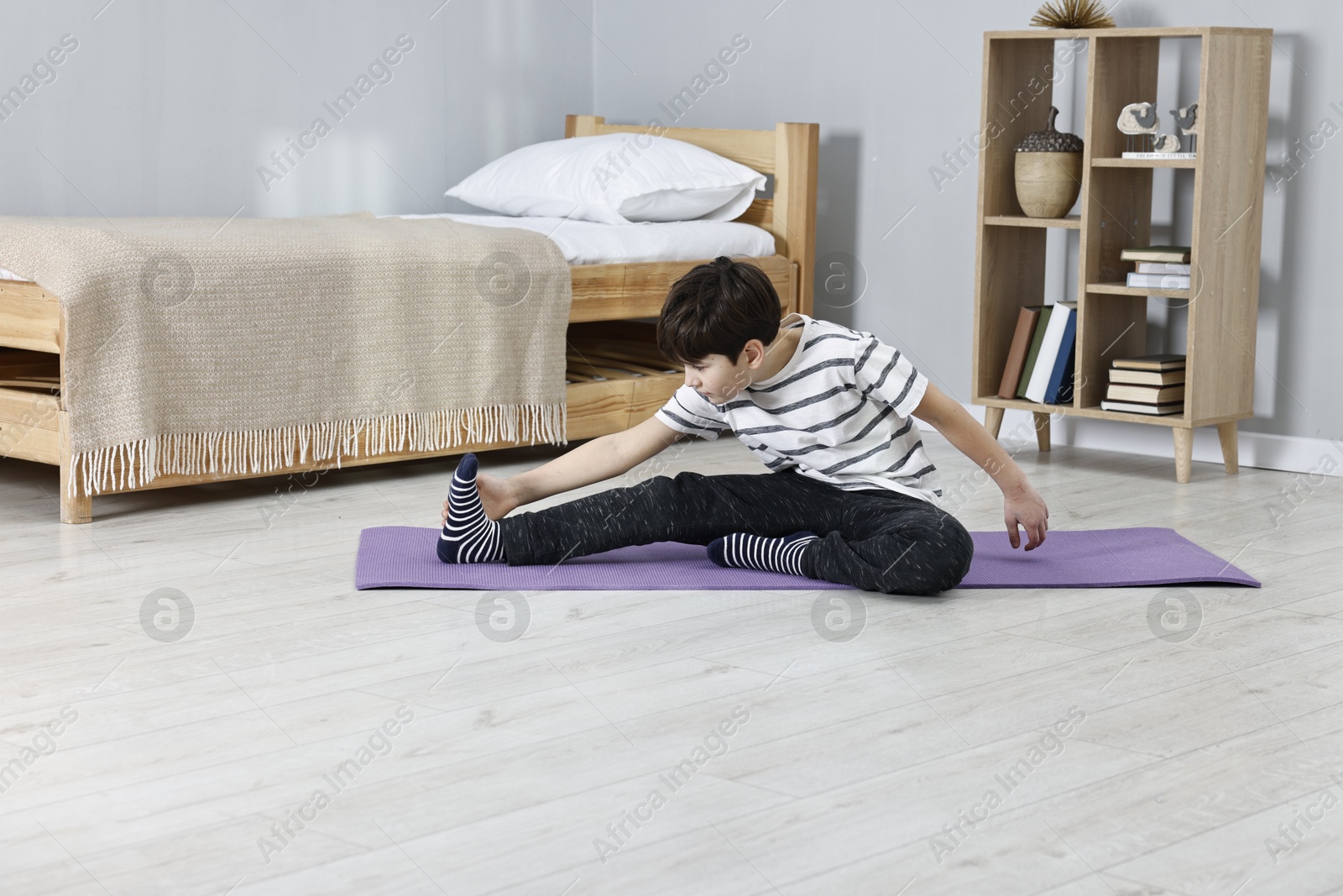 Photo of Little boy exercising at home. Morning routine