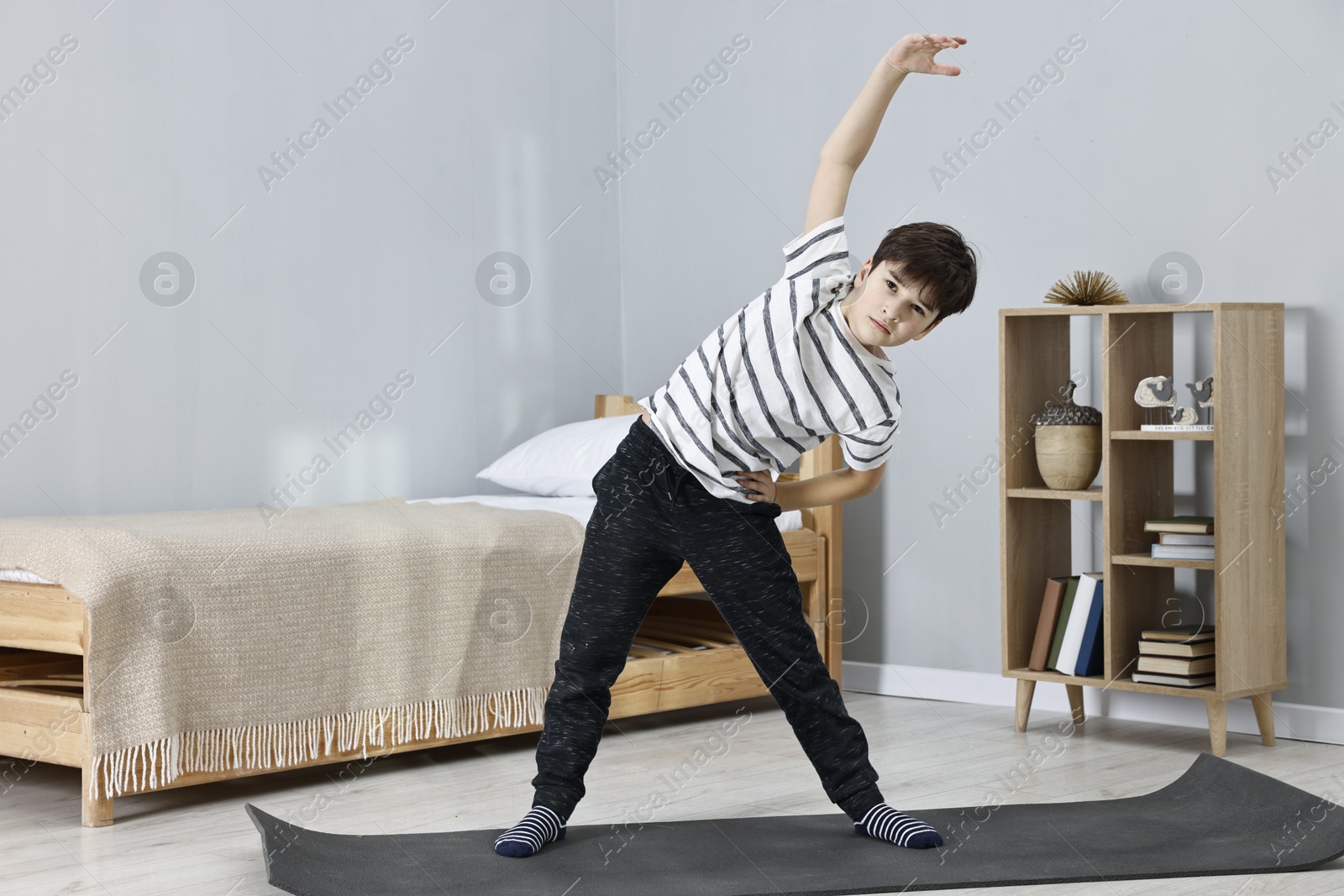 Photo of Little boy exercising at home. Morning routine