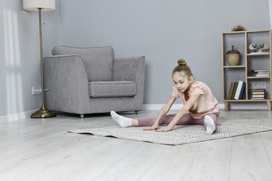 Photo of Little girl exercising at home. Morning routine