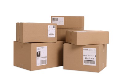 Photo of Many parcels with shipment labels isolated on white