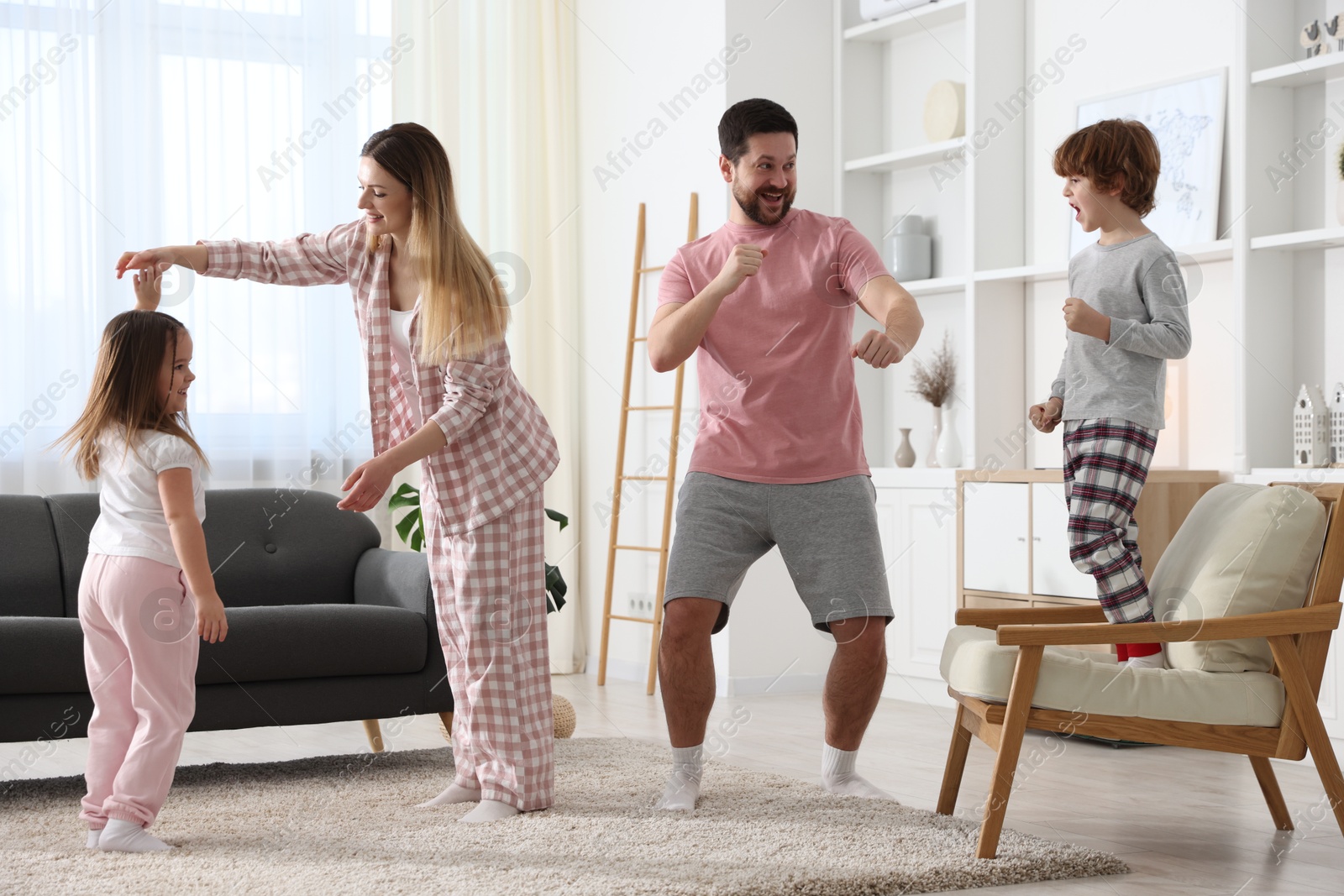 Photo of Happy family wearing stylish pajamas having fun at home