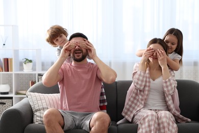 Photo of Happy family wearing stylish pajamas having fun on sofa at home