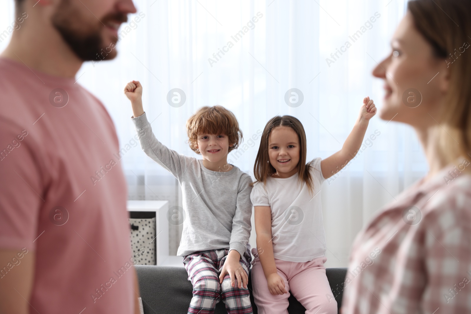 Photo of Happy family wearing stylish pajamas at home, selective focus