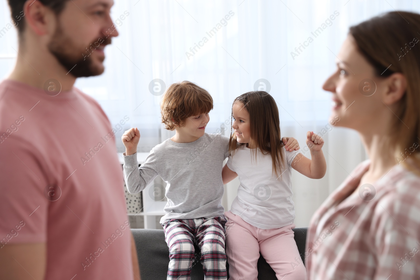 Photo of Happy family wearing stylish pajamas at home, selective focus