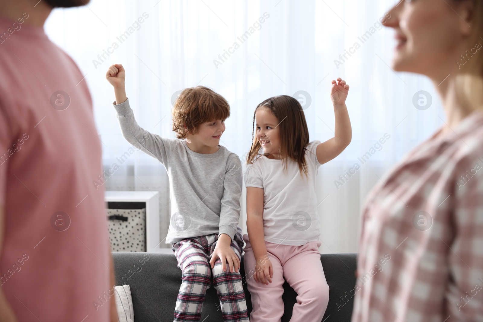 Photo of Happy family wearing stylish pajamas at home, selective focus