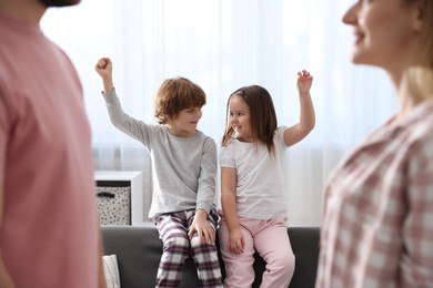 Photo of Happy family wearing stylish pajamas at home, selective focus