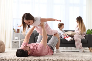 Photo of Happy family wearing stylish pajamas having fun at home, selective focus