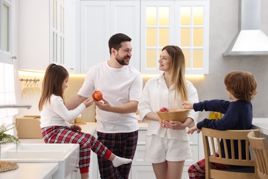 Photo of Happy family wearing stylish pajamas spending time together in kitchen