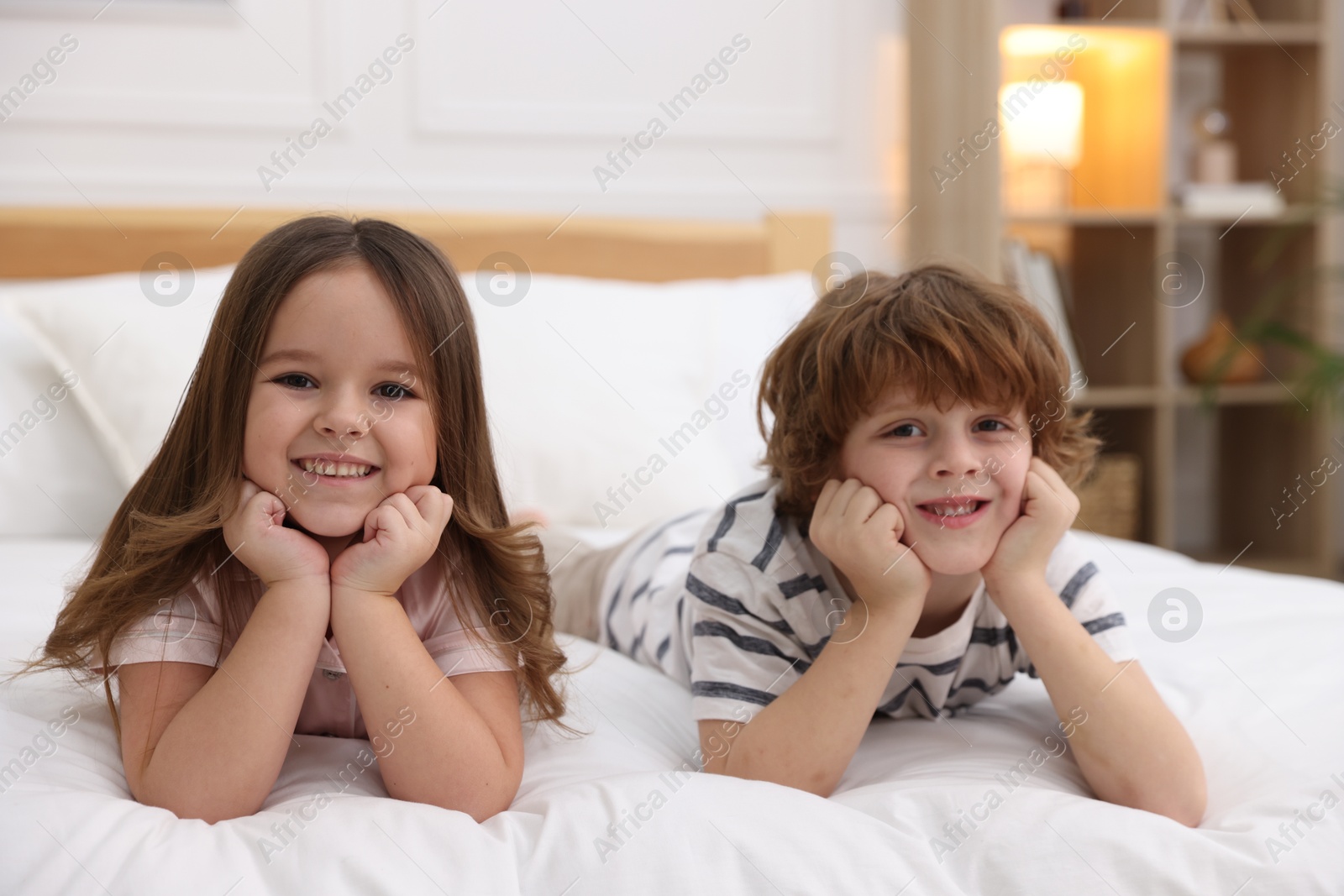 Photo of Family portrait of happy children wearing pajamas on bed at home