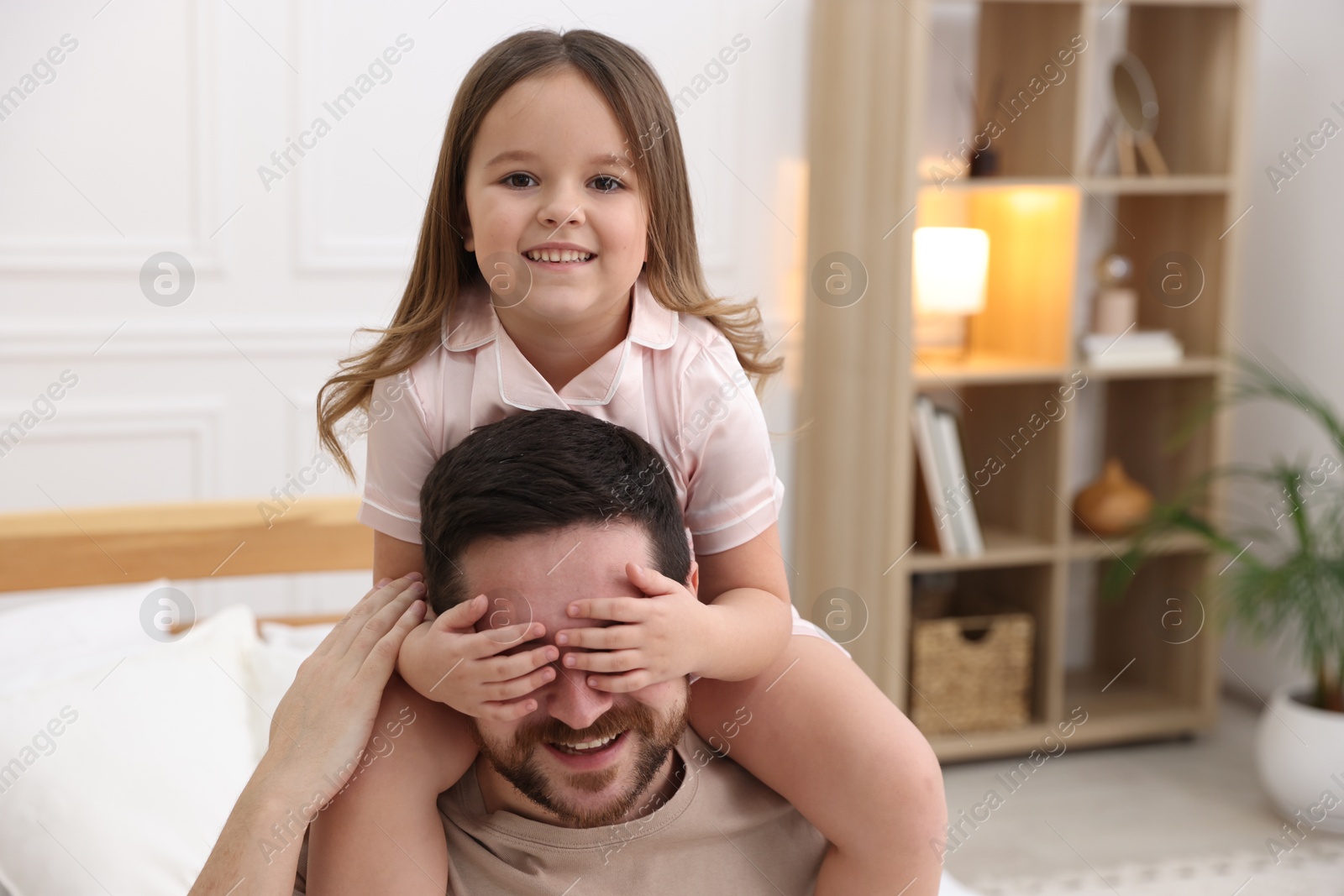 Photo of Happy father with his daughter wearing pajamas at home