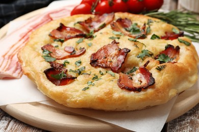 Photo of Delicious focaccia bread with bacon and parsley on wooden table, closeup