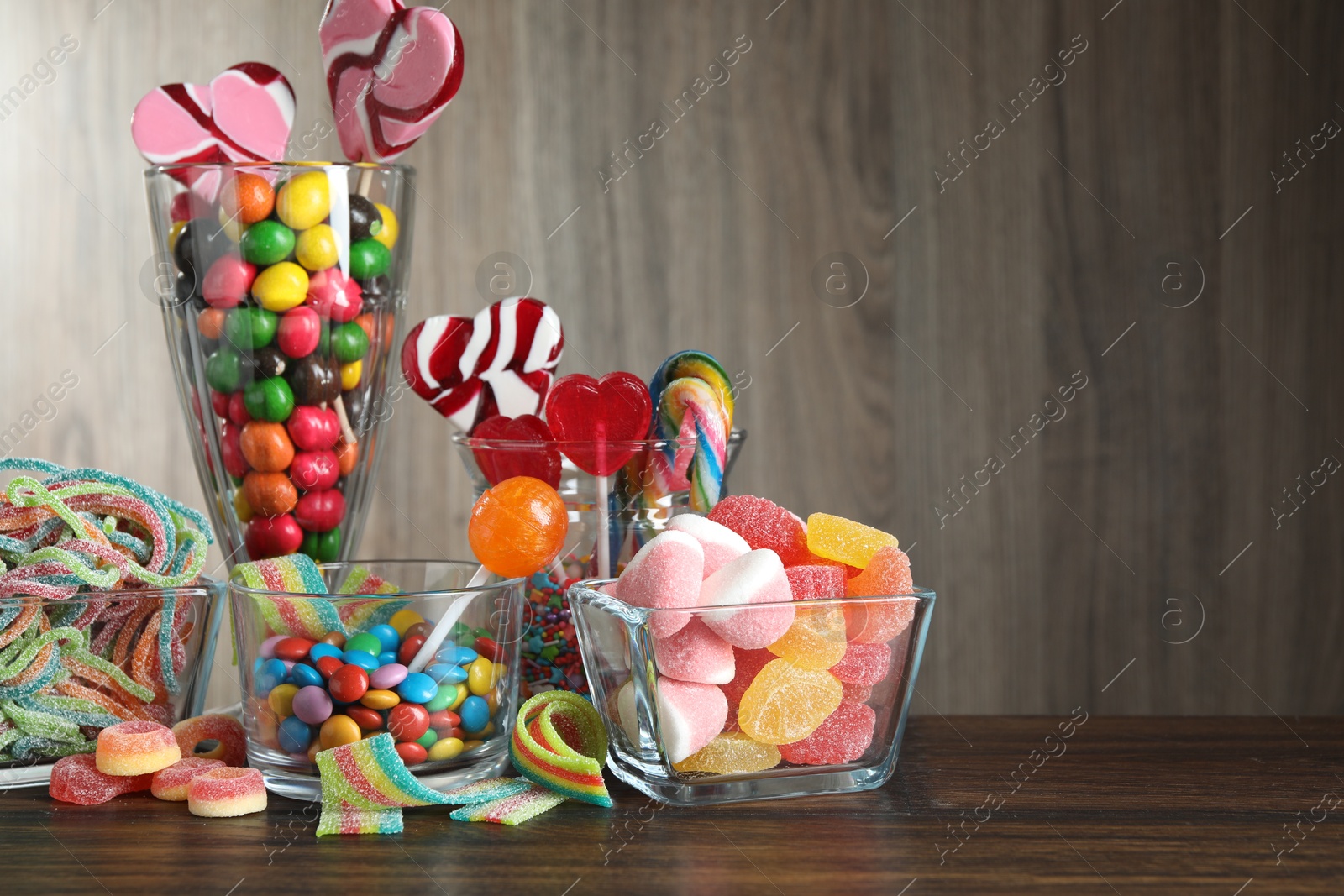 Photo of Candy bar. Many different tasty sweets on wooden table, space for text