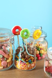 Photo of Candy bar. Many different sweets on wooden table against light blue background, closeup