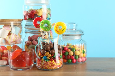 Photo of Candy bar. Many different sweets on wooden table against light blue background, closeup