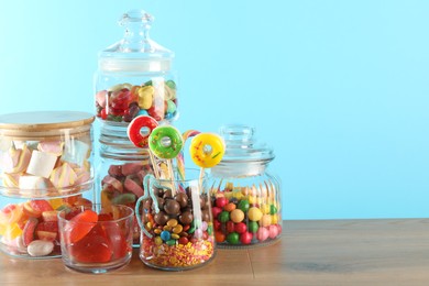 Photo of Candy bar. Many different sweets on wooden table against light blue background. Space for text