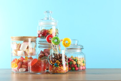 Photo of Candy bar. Many different sweets on wooden table against light blue background. Space for text