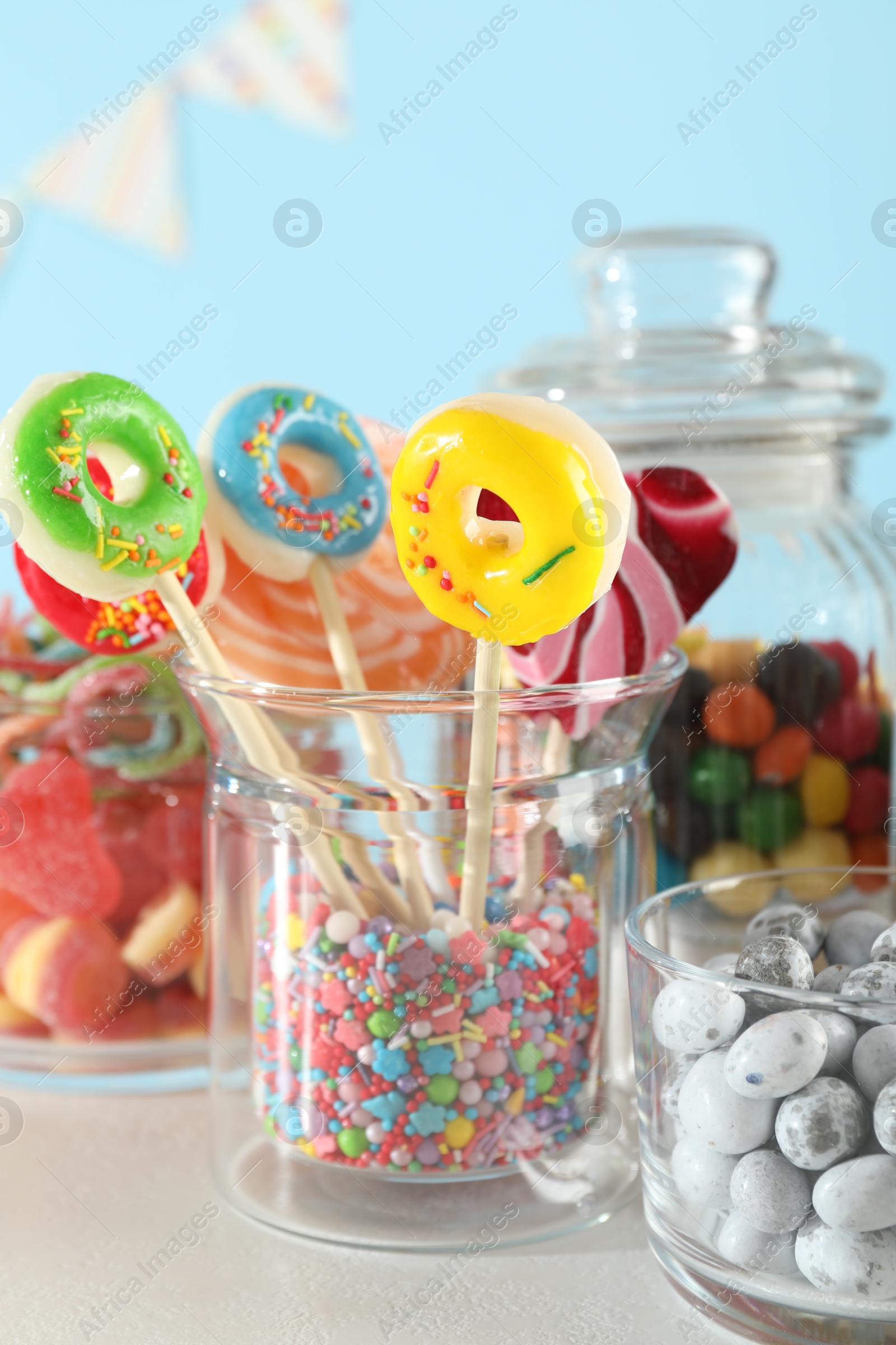 Photo of Candy bar. Many different sweets on white table against light blue background, closeup