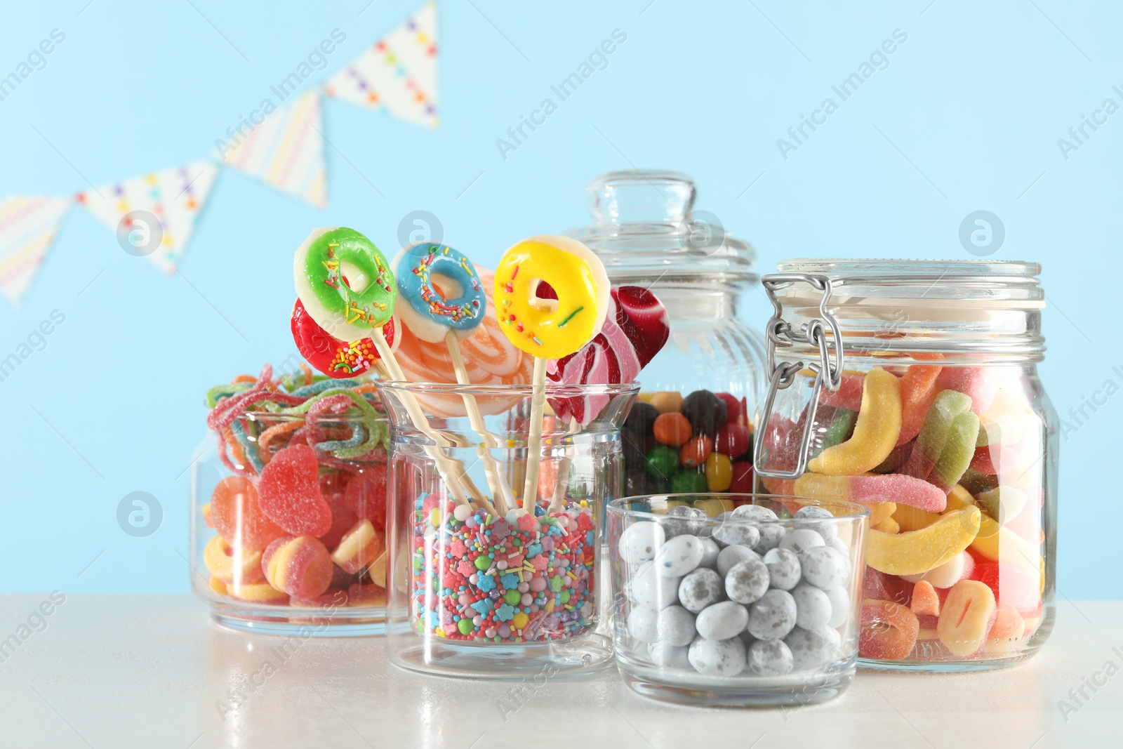 Photo of Candy bar. Many different sweets on white table against light blue background