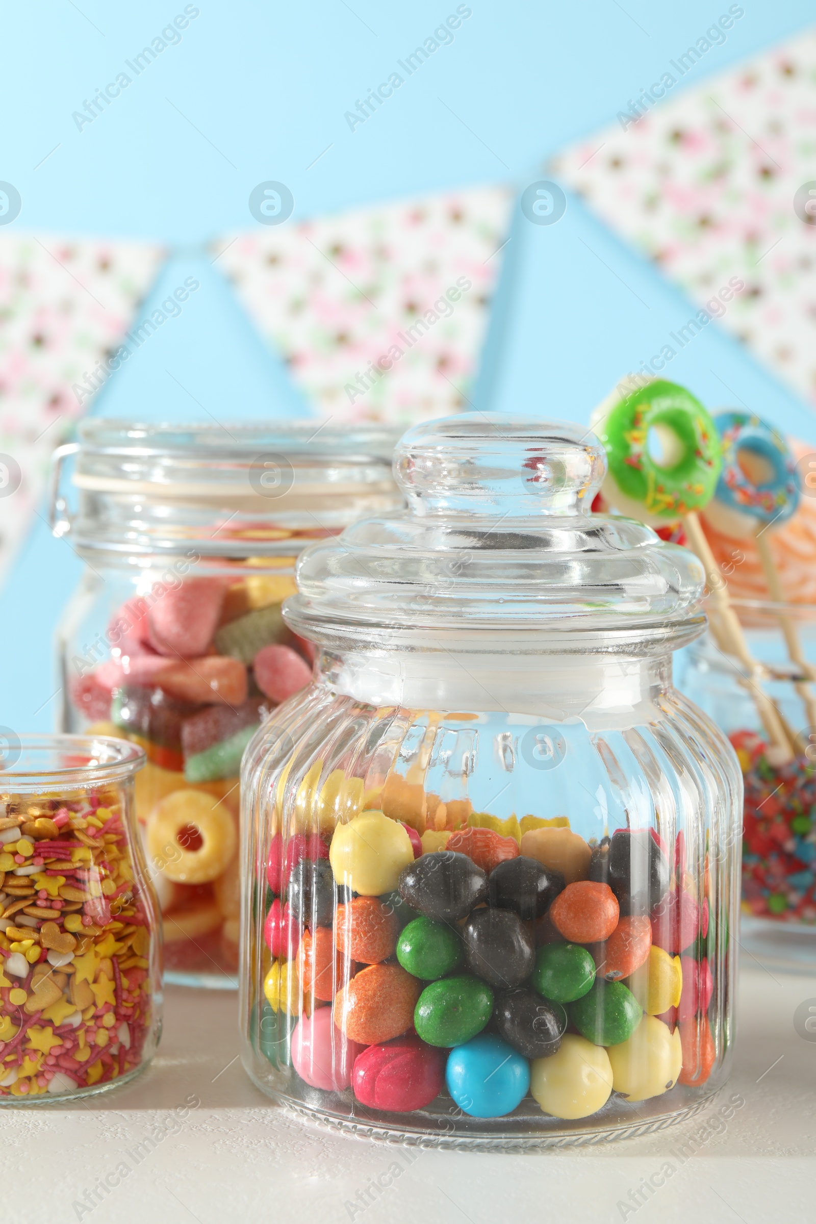 Photo of Candy bar. Many different sweets on white table against light blue background, closeup