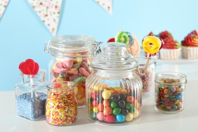 Photo of Candy bar. Many different sweets on white table against light blue background, closeup