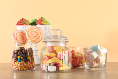 Photo of Candy bar. Many different sweets on wooden table against beige background. Space for text