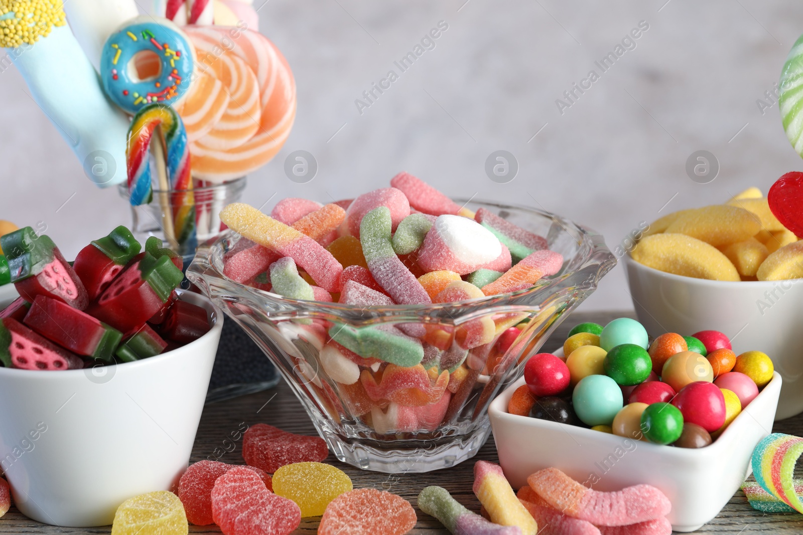 Photo of Candy bar. Many different sweets on wooden table against grey background, closeup