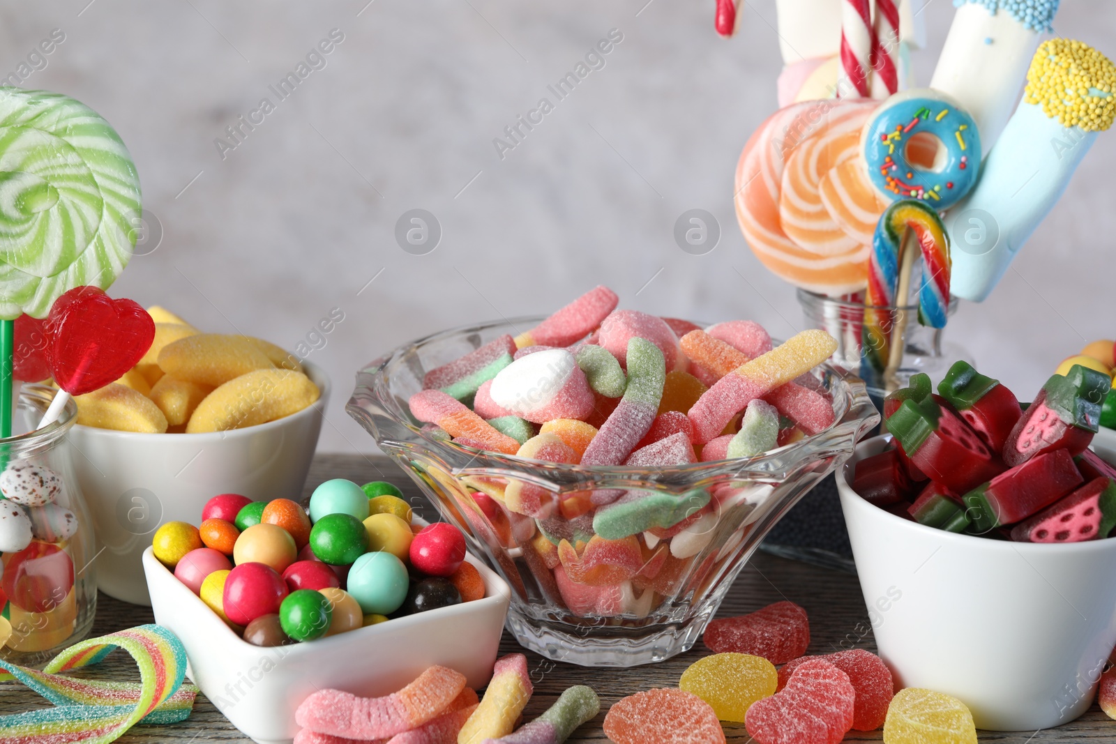 Photo of Candy bar. Many different sweets on wooden table against grey background, closeup