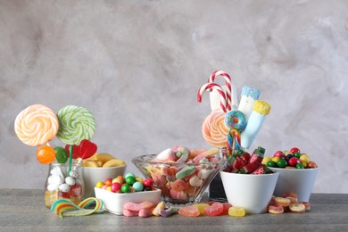 Candy bar. Many different sweets on wooden table against grey background. Space for text