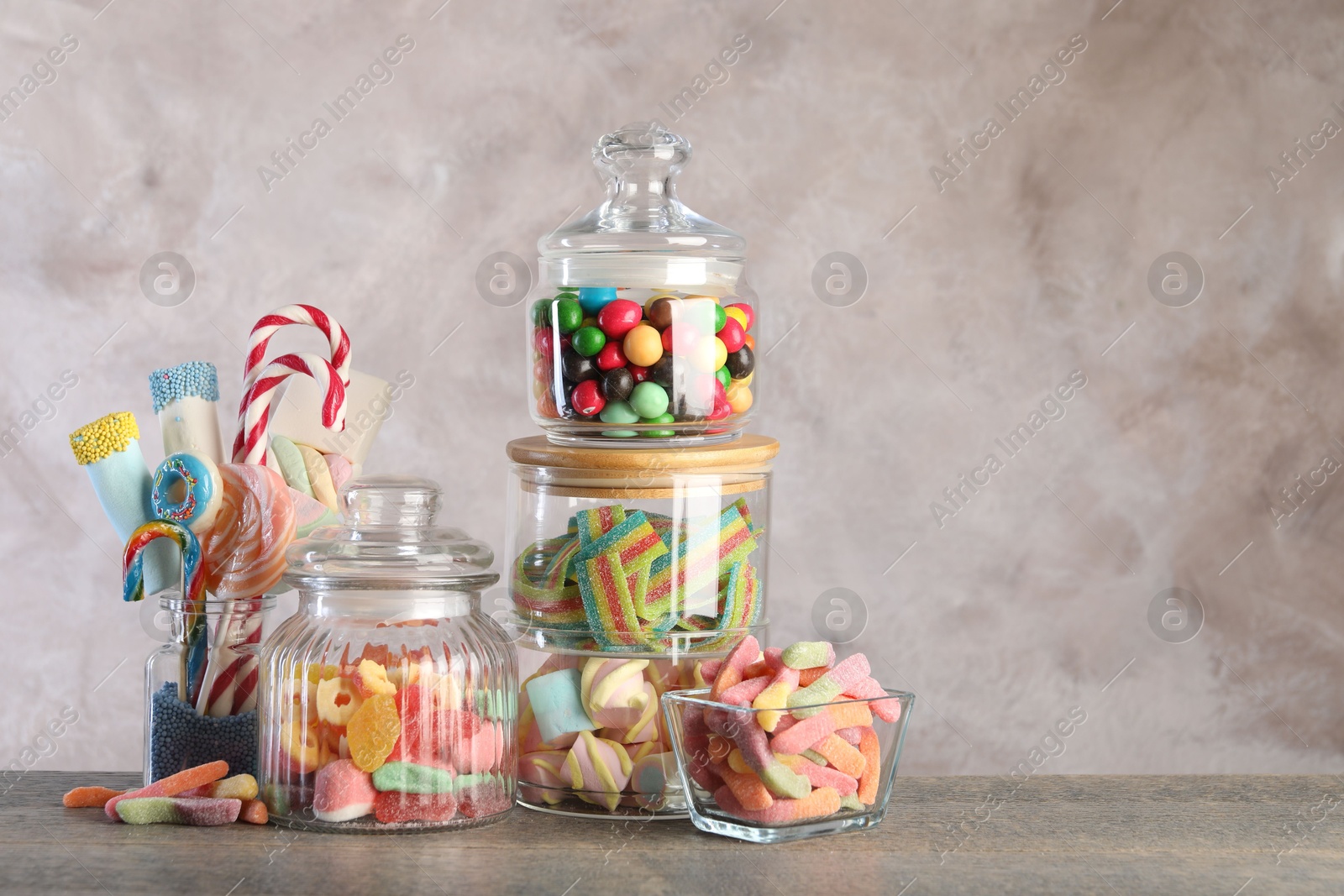 Photo of Candy bar. Many different sweets on wooden table against grey background. Space for text