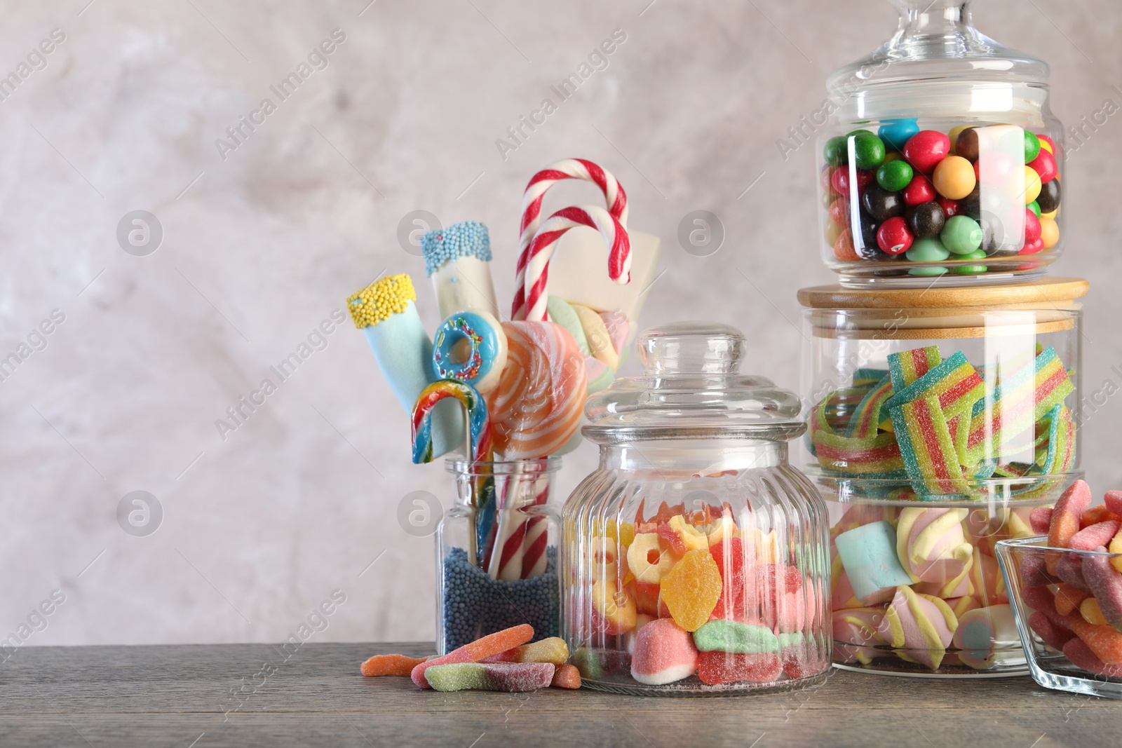 Photo of Candy bar. Many different sweets on wooden table against grey background. Space for text