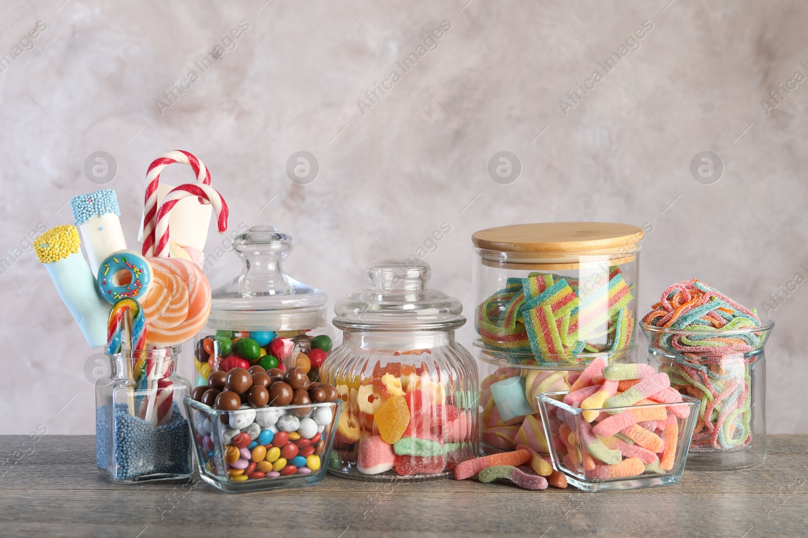 Photo of Candy bar. Many different sweets on wooden table against grey background. Space for text