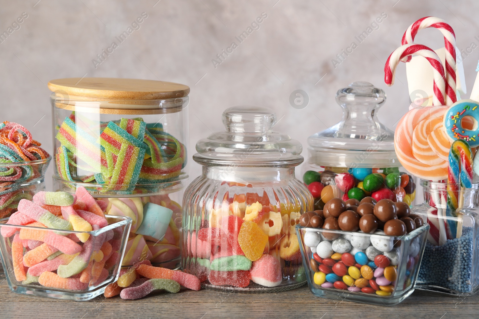 Photo of Candy bar. Many different sweets on wooden table against grey background, closeup