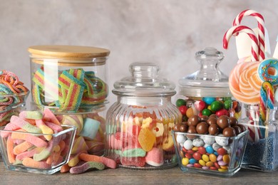 Candy bar. Many different sweets on wooden table against grey background, closeup