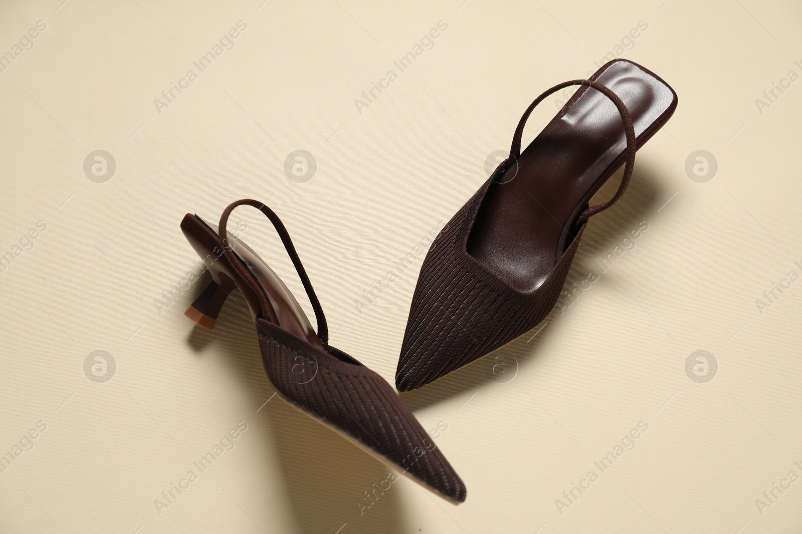 Photo of Stylish brown shoes on beige background, flat lay