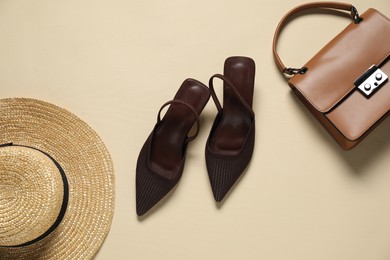 Photo of Stylish brown shoes, straw hat and bag on beige background, flat lay