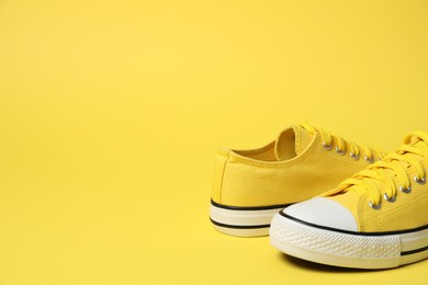 Photo of Sportive shoes. Color sneakers on yellow background, space for text