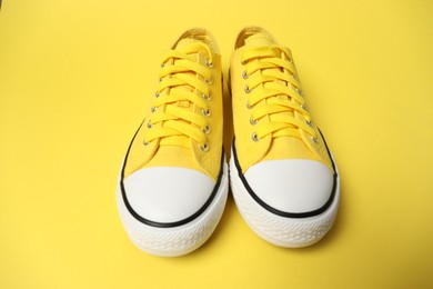 Photo of Color sneakers on yellow background. Sportive shoes