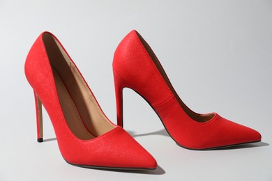 Photo of Red high heeled shoes on light background